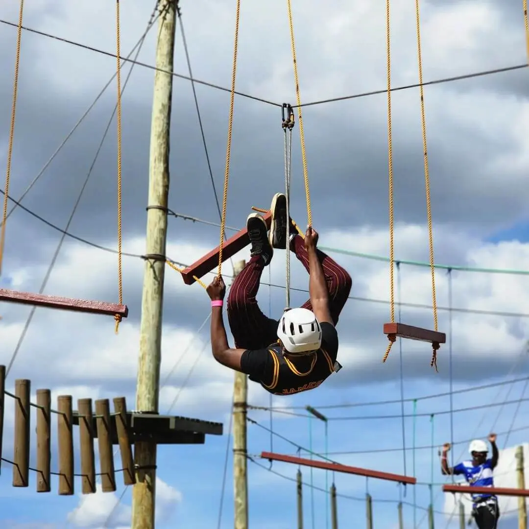 Adventurer tacking a high rope course obstacle with hanging ropes. Photography: Instagram @burudaniadventurepark