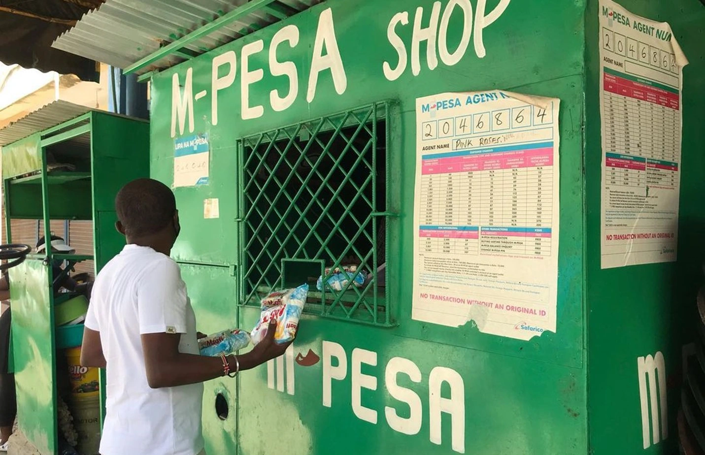 tourist withdrawing money from mpesa shop in Kenya